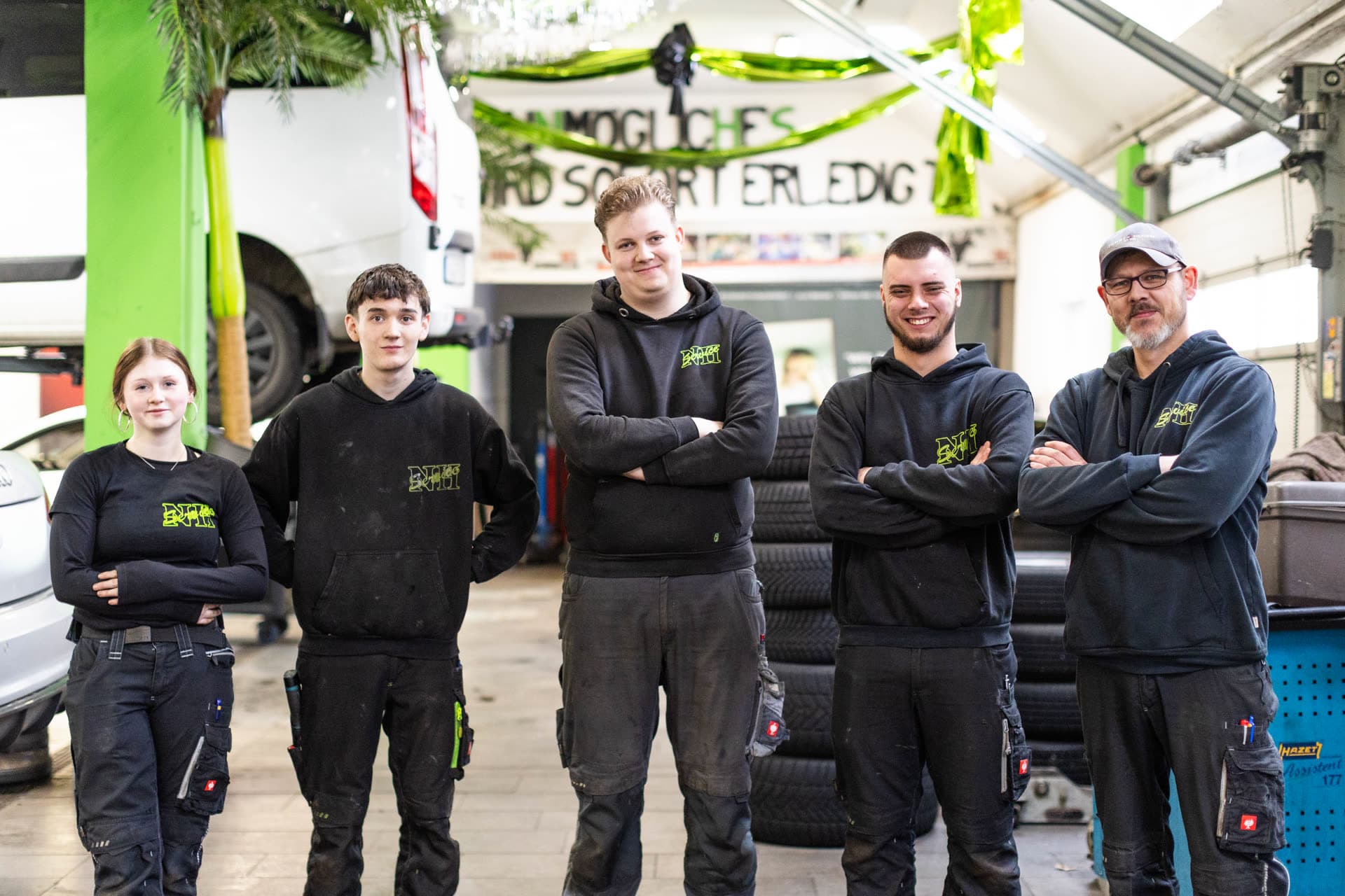 Das NH-Service Team in der Werkstatt - 5 Mitarbeiter in Arbeitskleidung